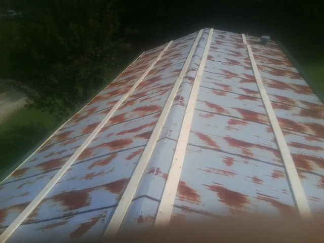 Rusted metal roof panels with new wood purlins before replacement — Storm Damage Roof Repair in Gwynn by Roofing Brothers
